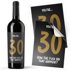 A black sticker with gold text on it, designed to be applied to an alcohol bottle, with the text 'YOU'RE.