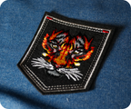 Tiger Face On Black Shield Iron On Patch (9 x 7.6cm)