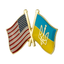 A pin badge featuring the American flag on one side and the Ukrainian flag with a trident on the other, against a white background.