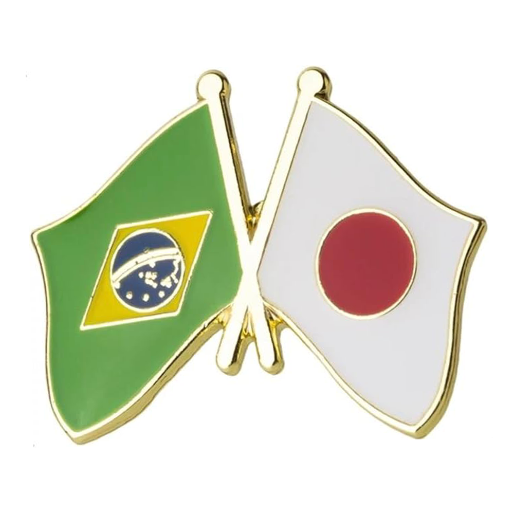 A pin badge featuring the flags of Brazil and Japan with a butterfly clutch, primarily in gold, green, white, and red colors. Imagen principal del producto