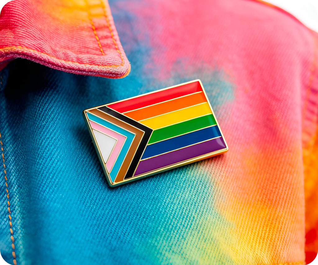 Insignia de pin rectangular con el mensaje "Progreso y orgullo"