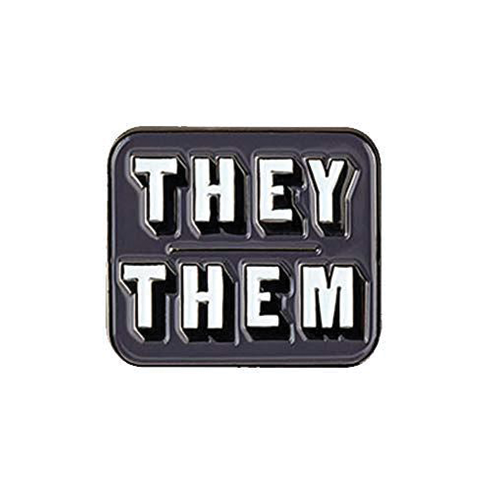 A square-shaped pin badge with 'THEY/THEM' text in bold, brass-plated iron with a butterfly clutch back. © Tigoli® 2026 All Rights Reserved Panda Loco Ltd 