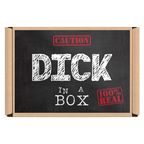 The image displays the packaging of the novelty gift item "Dick In a Box." The box, with a simplistic and bold design, features a chalkboard-style background with the humorous text "CAUTION: DICK IN A BOX REAL" highlighted in red. © Tigoli® 2026 All Rights Reserved Panda Loco Ltd 