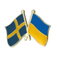 A badge featuring the Swedish and Ukrainian flags in blue, yellow, and red colors, with a butterfly clutch back. © Tigoli® 2026 All Rights Reserved Panda Loco Ltd 